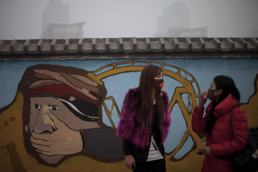 <p> In this Jan. 12, 2013 photo, a woman adjusts her mask while walking with her friend outside an amusement park on a polluted day in Beijing, China. Facing public outrage over smog-choked cities and filthy rivers, China's leaders are promising to clean up its neglected environment, a pledge that sets up a clash with political pressures to keep economic growth strong. (AP Photo/Alexander F. Yuan)