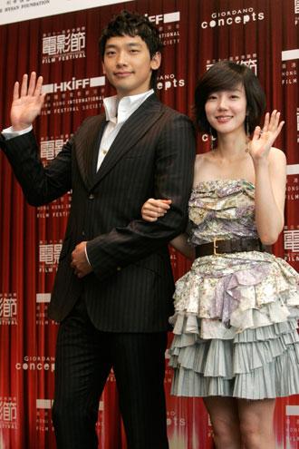 South Korean actress Lim Su-jeong (R) and actor Jung Ji-Hoon, also known as Rain, wave during a news conference in Hong Kong March 19, 2007. The gala premiere of their movie