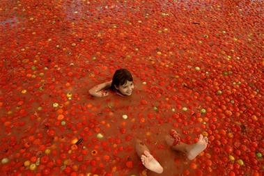 An Israeli girl floats in a pool of tomatoes during a tomato festival in the southern Israeli village of Yevul, next to the Egyptian border Thursday Oct. 12, 2006. The two-day annual tomato festival takes place during the Jewish holiday of Sukkot.